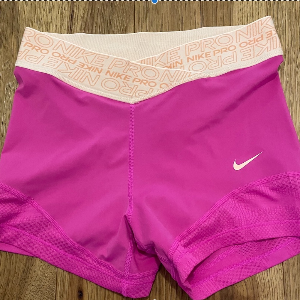 Pink nike pros, in a size small, with mess at the bottom of the shorts